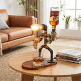 Decorative lamp made of pipes pouring a drink into a glass on a wooden table.